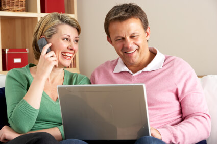 Middle-aged couple on the phone and computer